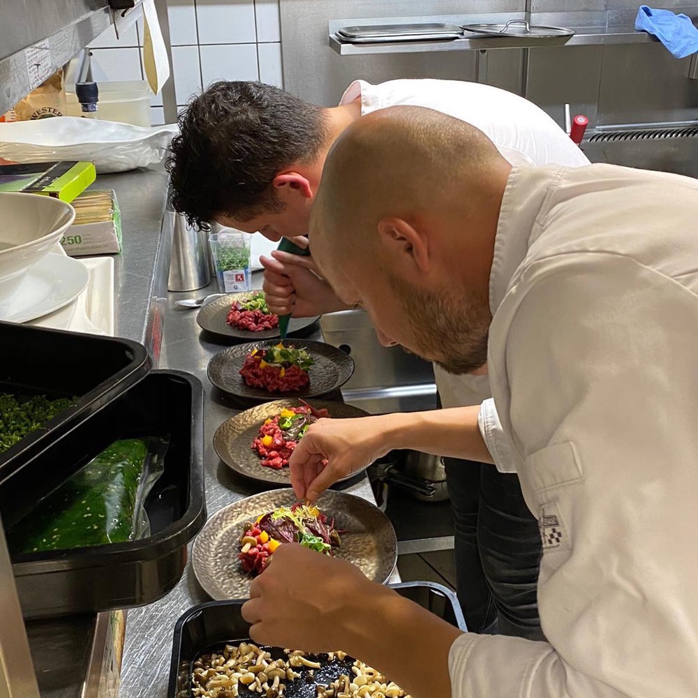 De chefs van Loef en Lij maken borden op in de keuken